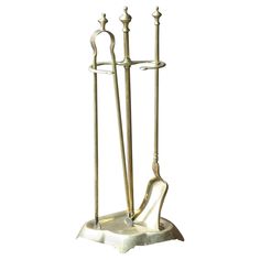 a metal candle holder with three candles and two spoons on it's stand