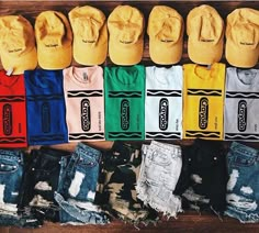 many different colored hats are lined up on top of each other in front of a wooden table