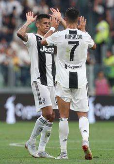 two soccer players congratulate each other on the field