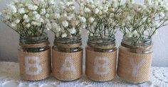 four mason jars with white flowers in them