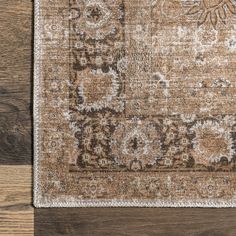 an area rug with brown and beige colors on top of wood flooring in a living room