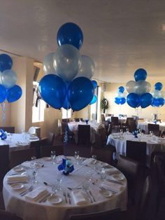 blue and white balloons fill the air over tables at a wedding or party reception in a banquet room