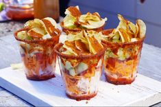 four glasses filled with food sitting on top of a table