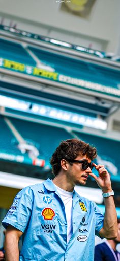 a man talking on a cell phone in front of a stadium