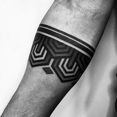 a black and white photo of a man's arm with a geometric tattoo on it