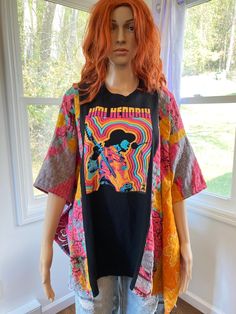 Jimi Hendrix psychedelic graphic t shirt upcycled into a beautiful loose fitting poncho top.  This top is one size fits all.  The poncho is constructed with cotton kantha fabric from recycled kantha blankets on the sides.  This fabric may contain patched areas and or flaws which is part of the character of kantha fabric.  The chest is 41.5 inches across, 83 inches around and it is 26.5 inches long.  The arm holes are 8.5 inches wide.  Machine wash cold gentle cycle tumble dry low. Multicolor Bohemian T-shirt For Beach, Oversized Bohemian Cotton T-shirt, Multicolor Bohemian T-shirt For The Beach, Bohemian Multicolor T-shirt For Beach, Bohemian Oversized Cotton T-shirt, Oversized Bohemian Short Sleeve Tops, Bohemian Oversized Short Sleeve Top, Oversized Graphic Print Festival Tops, Oversized Graphic Print Tops For Festivals