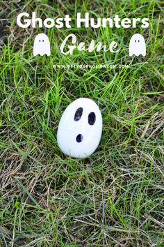 a white button sitting in the grass with ghost faces on it's face and text overlay that reads, ghost hunters game