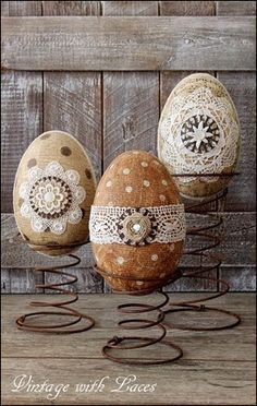 three decorated eggs sitting on top of a wooden table