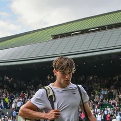 a male tennis player is standing in front of the crowd