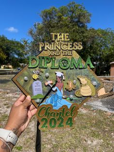 a hand holding up a sign that says the princess and the diploma