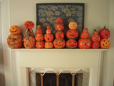 a mantle with pumpkins and decorations on it