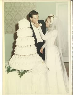 an old photo of a bride and groom about to cut their wedding cake