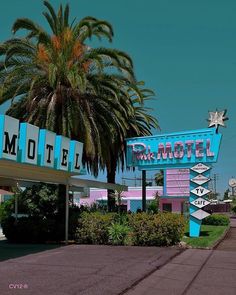 a motel sign with palm trees in the background