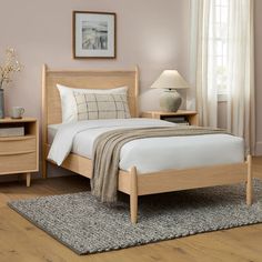 a bed room with a neatly made bed and two night stands on the side tables