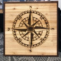 a wooden box with a compass etched on the front and sides, sitting on a table