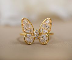 a close up of a butterfly ring on a table