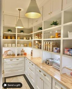 a kitchen filled with lots of white cupboards and counter top space next to a light fixture