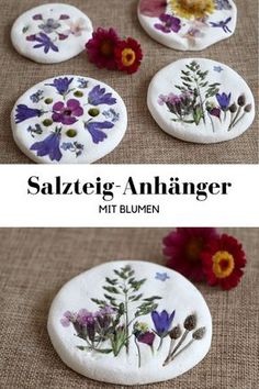 some flowers are painted on rocks with the words salzicg - anhanger