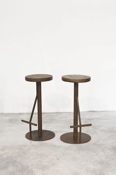 two stools sitting on top of each other in front of a white wall and floor