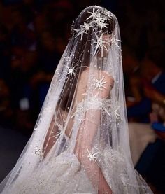 a woman wearing a wedding veil with stars on it