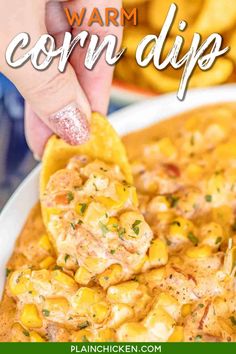 a person dipping corn into a bowl of chili and cheese dip with tortilla chips