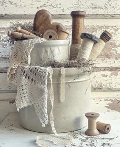 a white bucket filled with different types of sewing supplies