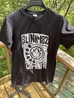 a black t - shirt with the words blinkin'on it hanging from a rail