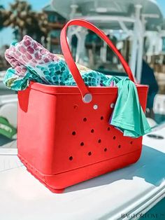 a red basket filled with clothes sitting on top of a boat