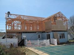 a house under construction in the middle of winter with wood framing on it's roof