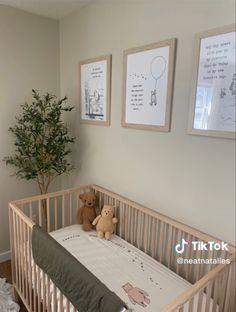 there is a baby crib with two teddy bears in it and pictures on the wall