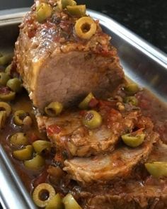 meat with olives and sauce in a metal pan