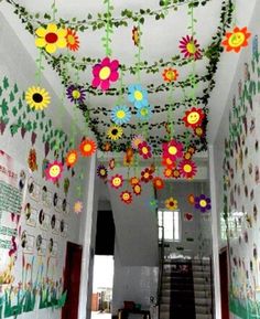 colorful paper flowers hang from the ceiling in a hallway