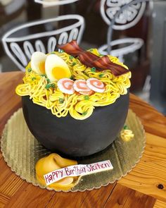 a birthday cake made to look like a bowl of noodles with eggs and bacon on top