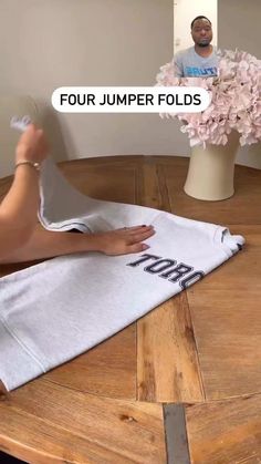 a person sitting at a table with their feet on a towel and the words four jumper folds