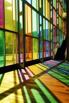 the sun shines through colorful windows in a building