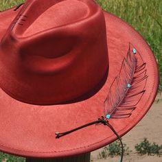 Experience the perfect blend of artisanal craftsmanship and cottagecore charm with our burned and distressed wide brim fedora hat. This red hat features unique hand-burned feather art created using the ancient art of pyrography, complemented by leather lacing and stunning turquoise accents. Meticulously crafted with freehand artistry, this one-of-a-kind fedora lets you showcase your individuality and style. Please note, for hygiene reasons, this item is non-refundable. Turquoise Flat Brim Handmade Hat, Handmade Turquoise Flat Brim Hat, Red Curved Brim Felt Hat For Festivals, Red Felt Hat With Curved Brim For Festivals, Red Brimmed Hat For Festival, Artisan Red Hats For Festival, Artisan Red Hat For Festivals, Artisan Red Festival Hat, Handmade Turquoise Brimmed Hat