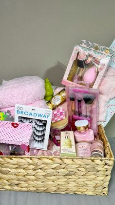 a basket filled with pink items on top of a bed