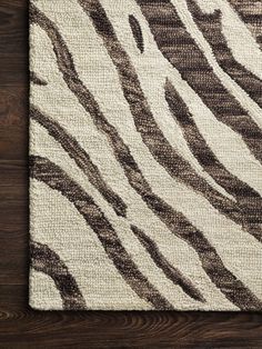 a brown and white rug on top of a wooden floor