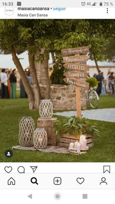 a wooden sign sitting on top of a lush green field