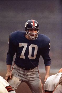 a football player standing on the field with his hands in his pockets and wearing a helmet