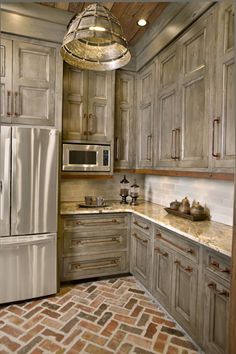 a kitchen with wooden cabinets and granite counter tops, stainless steel refrigerator and microwave oven