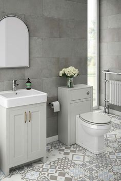 a white toilet sitting next to a sink in a bathroom under a mirror and a radiator