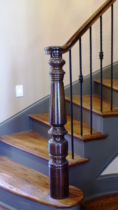 a wooden stair case next to a set of stairs