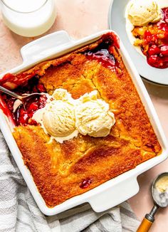 a dessert dish with ice cream and strawberry cobbler in the center on a table