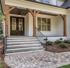 a white house with steps leading up to the front door and entry way that leads into the home