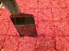 a spatula is being used to scoop ground beef into the ground for meat patties