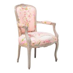 a pink chair with floral fabric on it's back and armrests, sitting in front of a white background