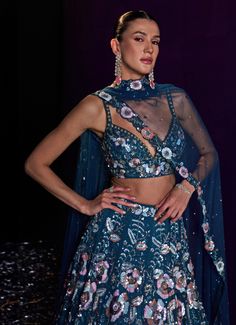 This stunning Peacock Blue Sequins Embroidered Bridal Lehenga Set is a masterpiece of intricate craftsmanship and vibrant elegance. Crafted from soft net fabric, the flowing blue lehenga is adorned with multicolored cut sequins, crystals, and bugle beads, creating a mesmerizing blend of colors and textures. The rich peacock blue fabric serves as a luxurious backdrop for the detailed embroidery, offering a captivating contrast that is both modern and timeless. Paired with a beautifully embellished blouse with a flattering neckline. The look is completed with a sheer dupatta that adds an extra layer of sophistication. This outfit is perfect for a bride or bride-to-be, especially for Cocktail or Sangeet parties, ensuring you make a statement on your special day. Composition : Lehenga, Blouse Fitted Blue Pre-draped Saree With Intricate Embroidery, Blue Bollywood Organza Choli, Blue Organza Bollywood Choli, Blue Organza Lehenga With Intricate Embroidery, Blue Bollywood Style Organza Choli, Blue Bollywood Choli In Organza, Blue Organza Choli With Sheer Dupatta, Blue Anarkali Net Dupatta, Blue Anarkali Style Net Dupatta