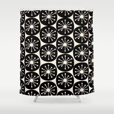 a black and white shower curtain with an abstract design in the center, on top of a