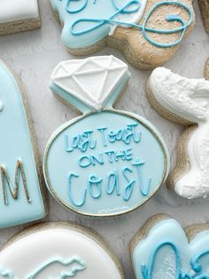 cookies decorated with blue icing and white frosting are on a table next to each other